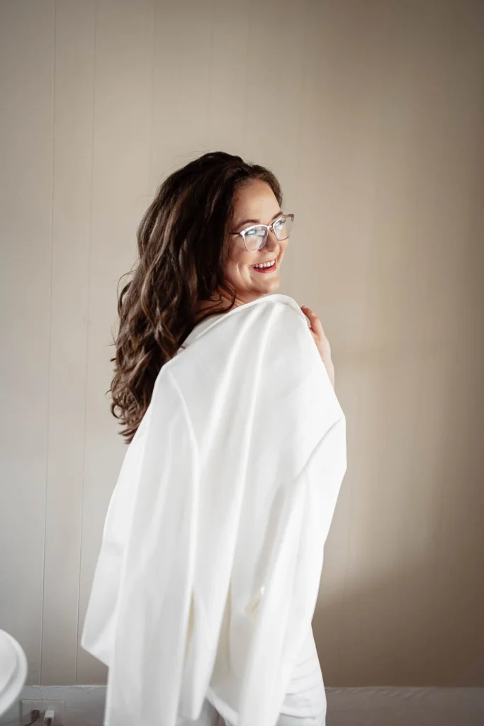 Stefanie Morris smiles holding white suit jacket over shoulder