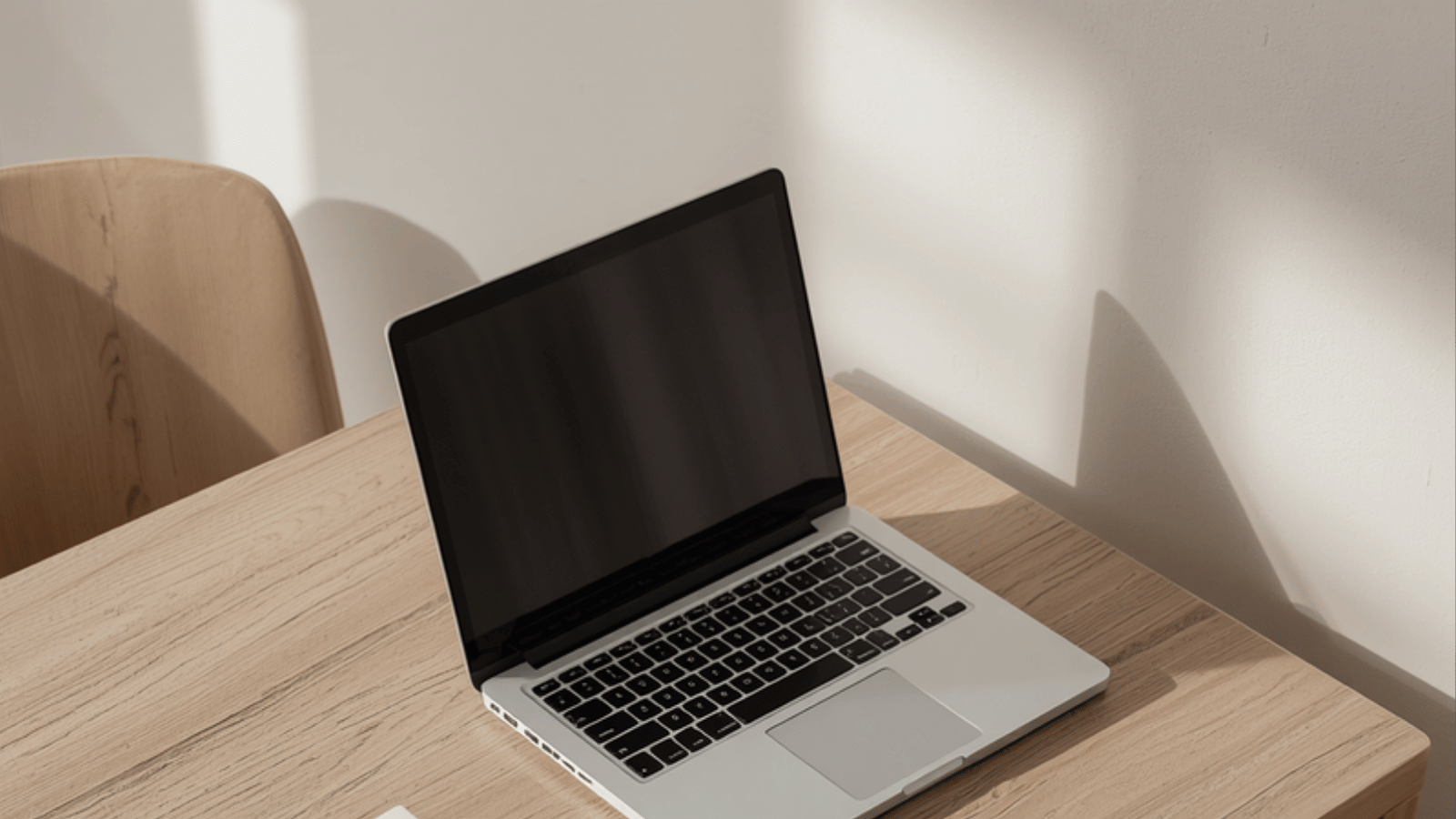 Open laptop on a wood desk in soft natural light, ready for blogging