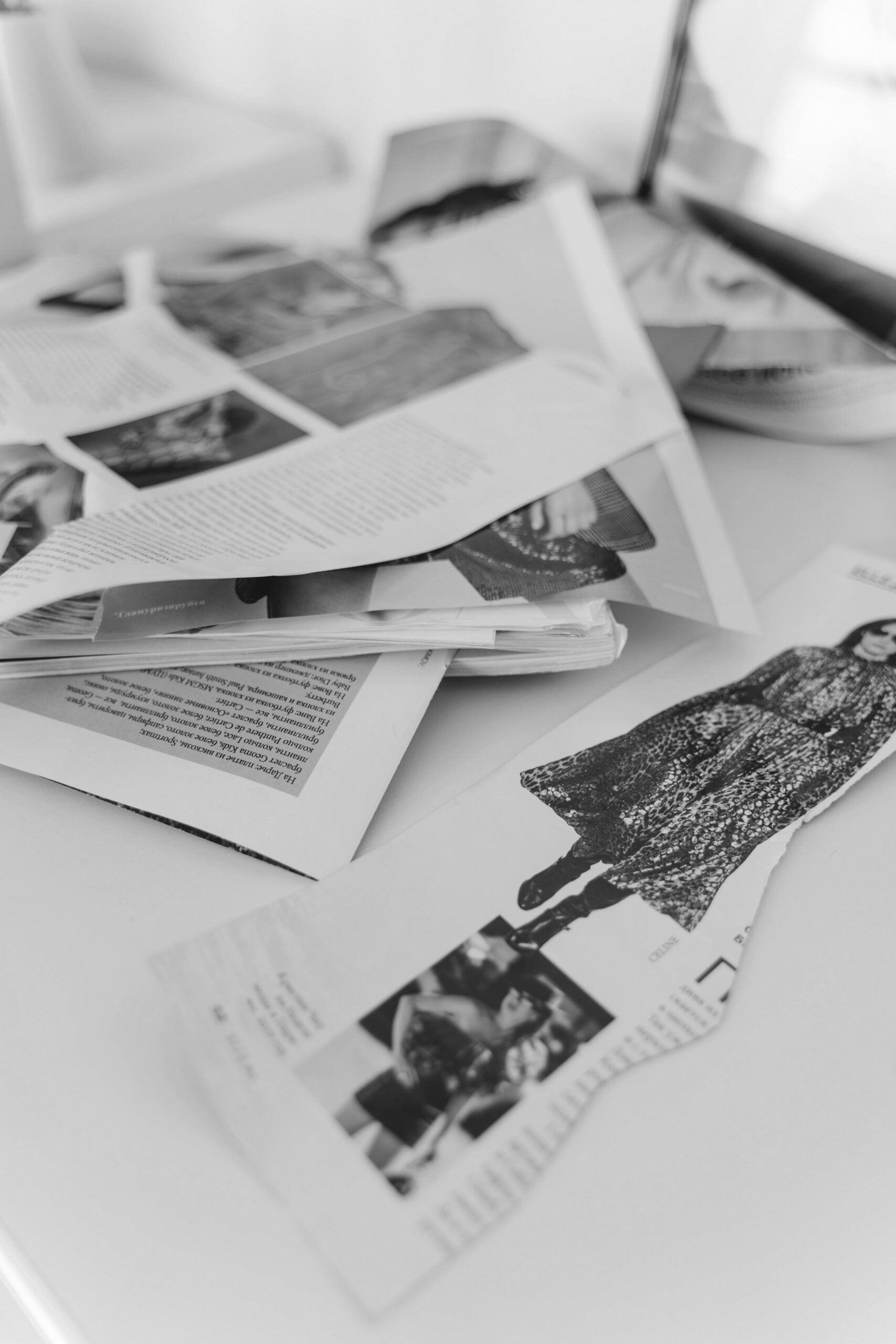 Magazine clippings and torn pages scattered across a white surface