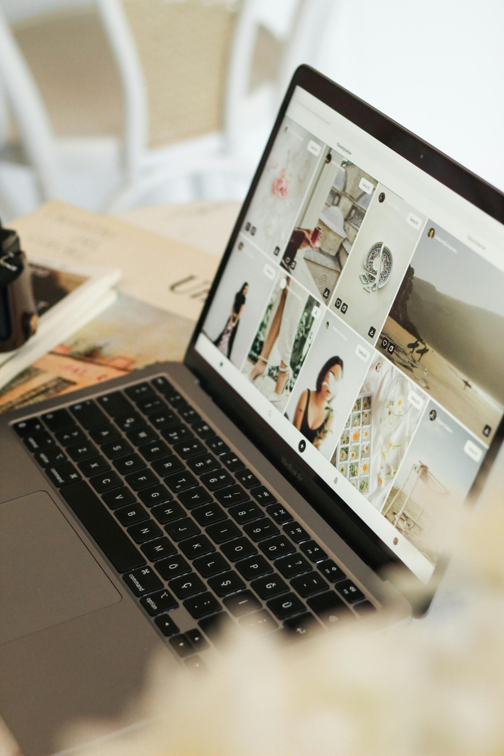 Laptop displaying a grid of lifestyle and fashion photos on a social media browsing feed