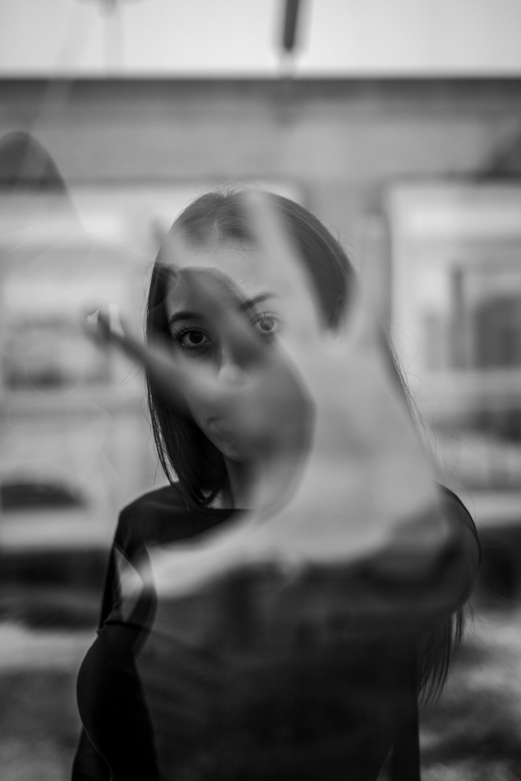 Black and white portrait of a woman with a distorted, ghostly double-exposure effect obscuring part of her face
