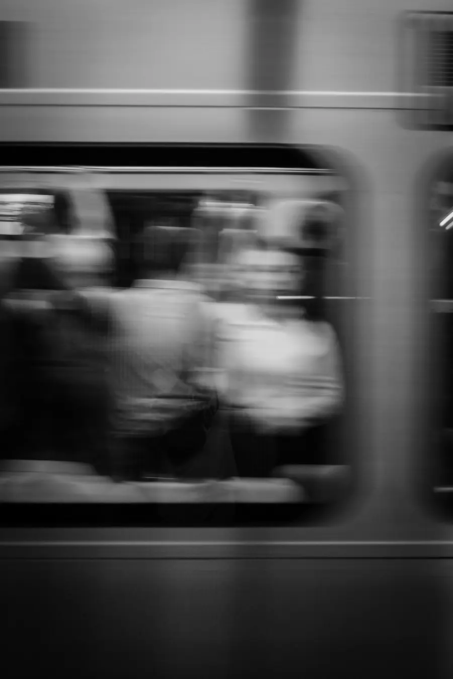 Black and white motion blur of a train passing through a station, the pace of a busy creative business