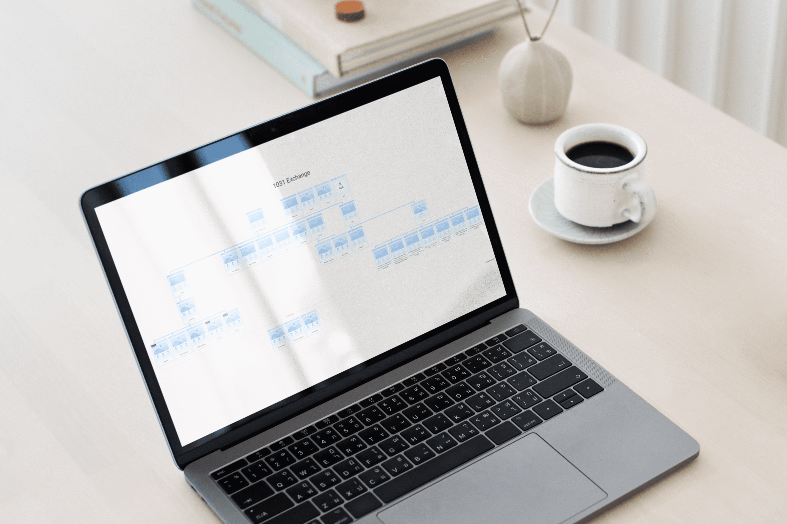 Laptop on a desk displaying a 1031 exchange flowchart diagram, with a coffee cup and books in the background