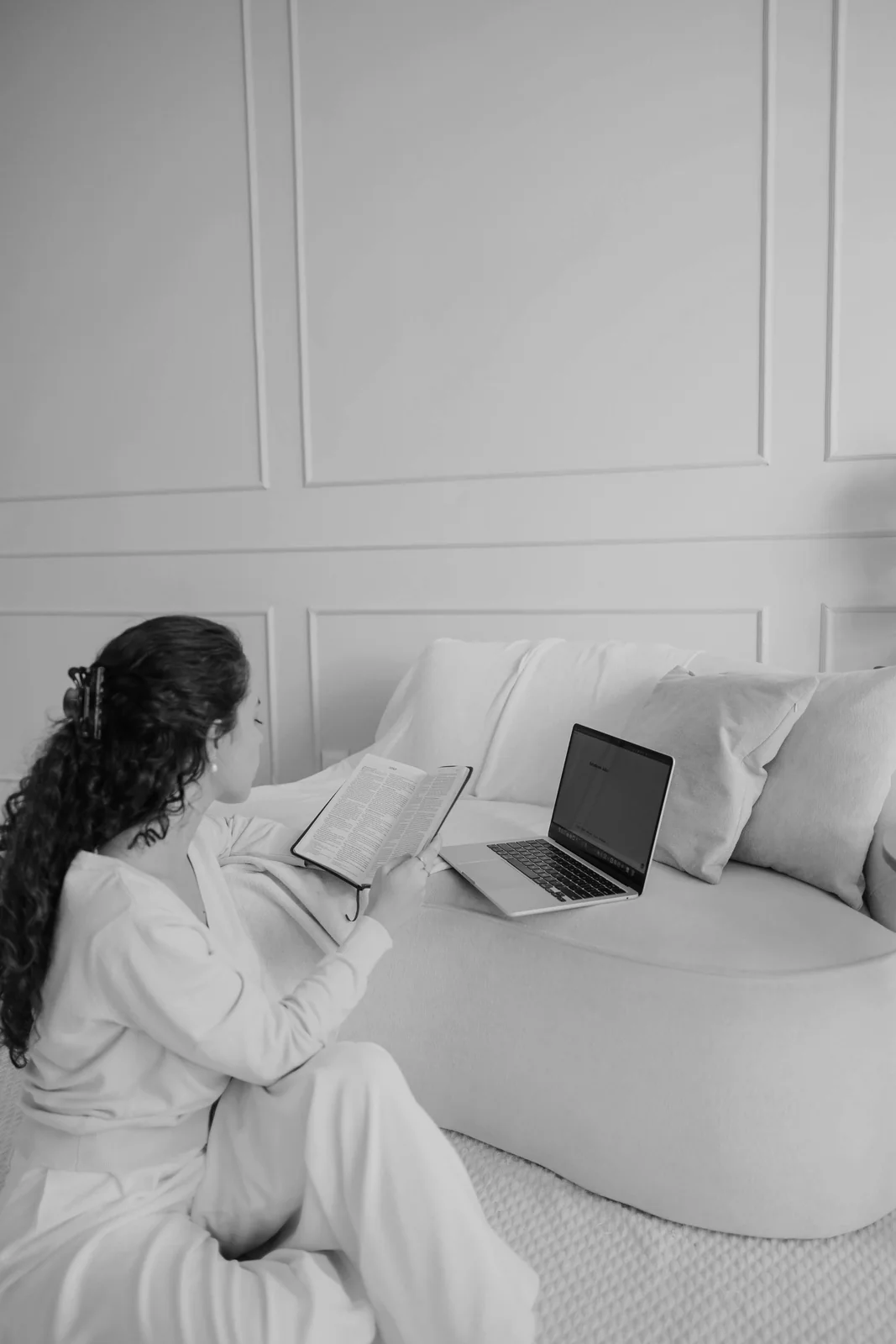 Showit Website Maintenance Guide Creative business owner sitting in a bright room with an open laptop, checking her Showit website