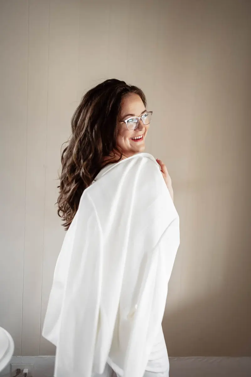 Stefanie morris, founder of morris and co marketing, in a white suit smiling over her shoulder