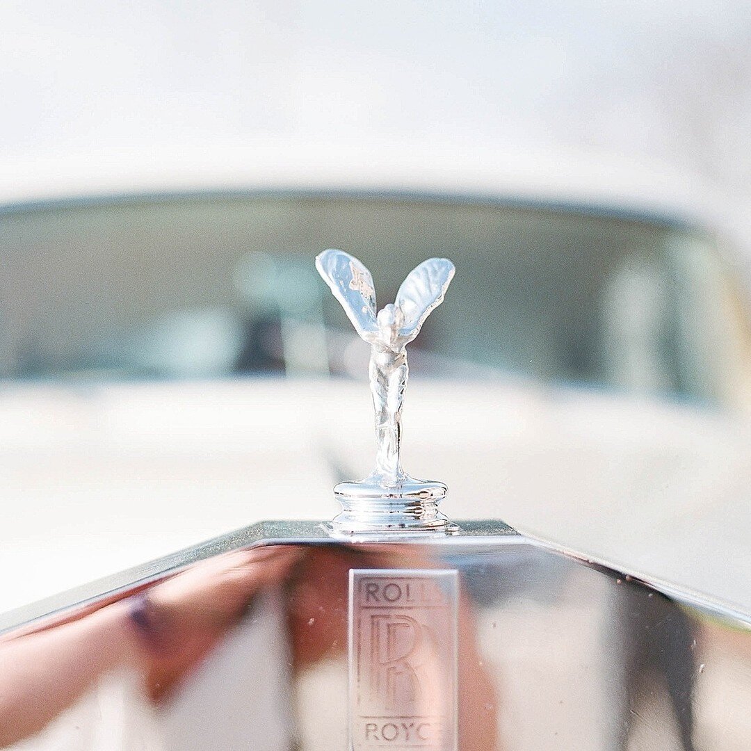 Rolls-royce "spirit of ecstasy" hood ornament and grille badge on a white car
